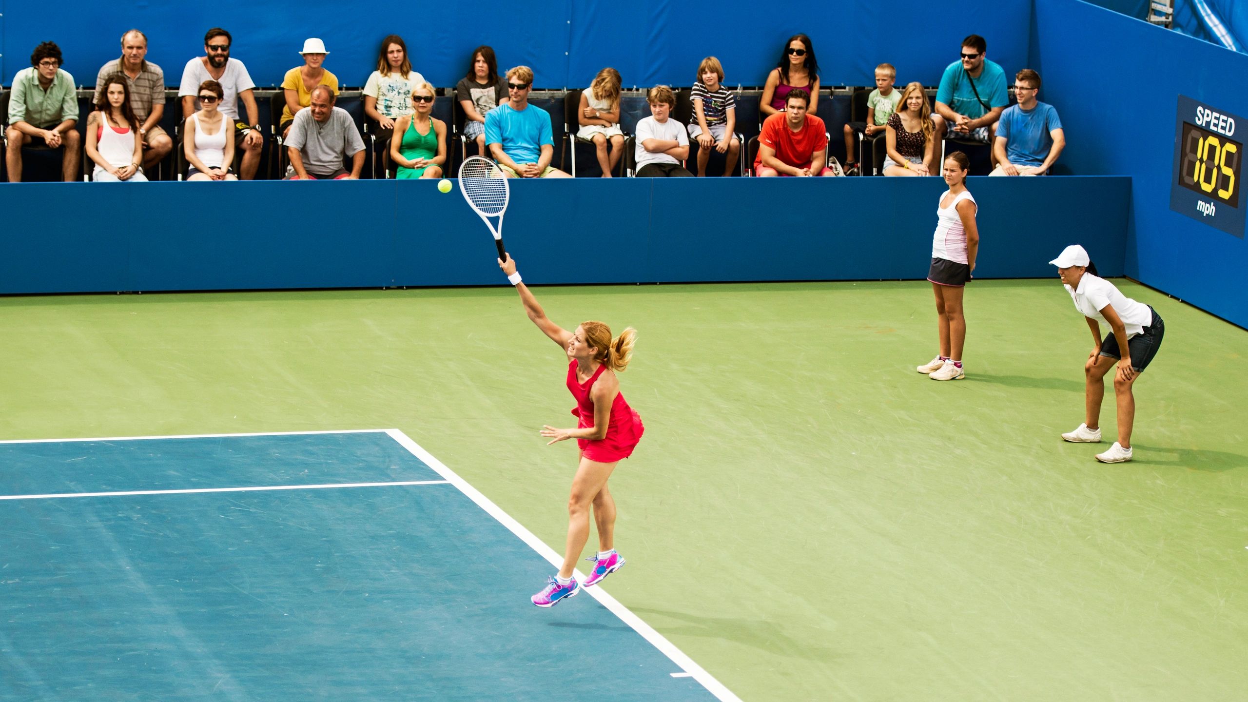 Professional tennis player serving in a stadium